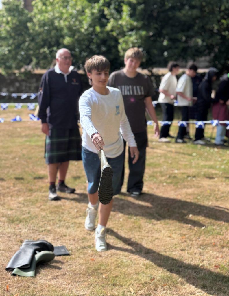 Participant competing in the Wellie Hurling at a Wild Cairns Mobile Highland Games